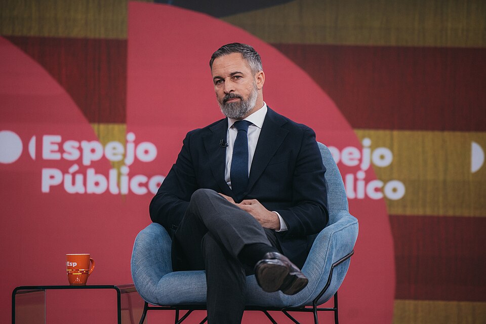Santiago Abascal sentado durante una entrevista en Espejo Público, vestido con traje oscuro y corbata, con el rostro completo visible.